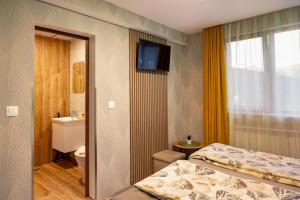 a room with two beds and a bathroom with a television at Къща за гости Мурите in Sapareva Banya
