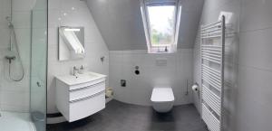 a white bathroom with a toilet and a sink at Premium Apart Villa Hamburg in Hamburg +19 photos