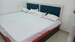 a bed with white pillows on it in a room at Hotel Janki Inn in Deoghar