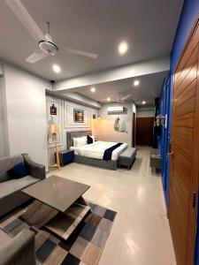 a bedroom with a bed and a couch and a table at Seashell Legacy Hotel in Karachi