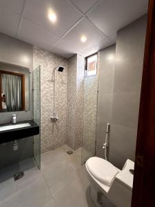 a bathroom with a shower and a toilet and a sink at Seashell Legacy Hotel in Karachi