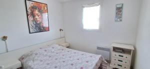 a bedroom with a bed and a painting on the wall at 3 pièces proche plage commerces et golf in Pornic +11 photos