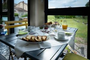 a table with a plate of food and drinks on it at Chambres d'hôtes Ecole Buissonnière en Dordogne in Le Buisson de Cadouin