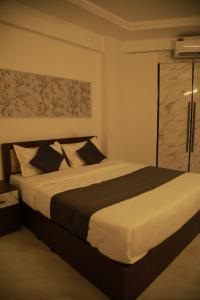 a bedroom with a large bed in a room at Rivayn Suites in Thiruvalla