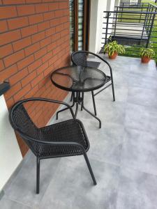 two chairs and a table on a patio at Apartament przy Matce Polce in Łódź +5 photos