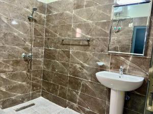a bathroom with a shower and a sink and a mirror at Midtown Appart Hôtel in Nouadhibou +24 photos