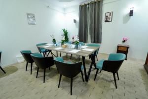 a dining room with a table and blue chairs at فندق ندى الفيروز in Az Zāhir