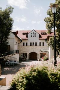 a large white building with a large garage at Hotel Vinnica in Wieliczka