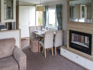 a living room with a table and a fireplace at Birch 2 - Ukc8215 in Pendine