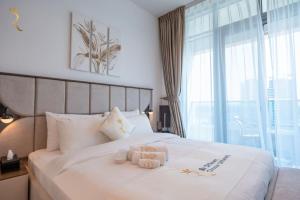 a bedroom with a bed with two towels on it at Pearl 1BR Al Reem - Serene Luxe Escape in Abu Dhabi +31 photos