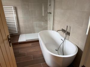 a white bath tub in a bathroom with a shower at The Ainsty in Thorp Arch