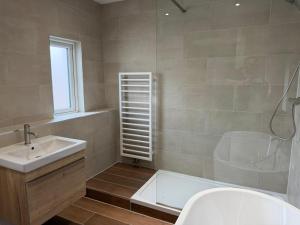 a bathroom with a tub and a sink and a shower at The Ainsty in Thorp Arch