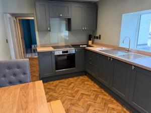 a kitchen with gray cabinets and a wooden floor at The Ainsty in Thorp Arch +5 photos
