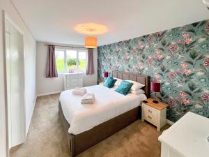 a bedroom with a bed with a floral wallpaper at Primrose Apartment - Uk49291 in Woolfardisworthy