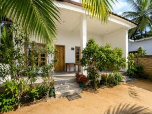 a house with trees and plants in front of it at Stay at arugambay in Pottuvil