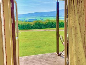 an open door to a porch with a chair outside at Skylark Lodge - Uk51678 in Carsethorn