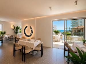 a restaurant with tables and chairs and a view of the ocean at Schiavon Beach Palace in Lido di Jesolo