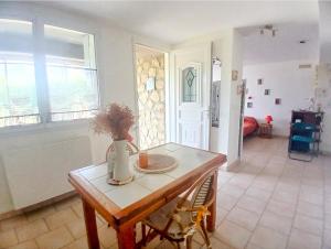 a living room with a table with a vase on it at Chez Lulu Grand Studio Cote Jardin avec Veranda in Saint-Sernin