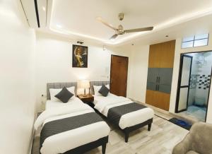 a bedroom with two beds and a ceiling fan at Holiday Out hotel in Jodhpur