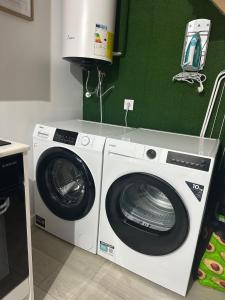 a washer and dryer in a room with a green wall at Cantinho Da Lapa in Porto