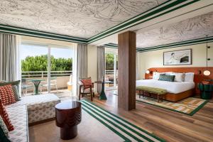a bedroom with a bed and a living room at Kimpton Quinta da Marinha by IHG in Cascais