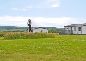 a statue in a field with a house in the background at Lillyhall Lodge Retreat in Workington