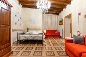 a bedroom with a bed and a couch and a chandelier at B&B Le Carrube in Sava +110 photos