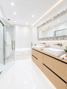 a white bathroom with two sinks and a mirror at Le Palais Aubernon in Antibes +53 photos