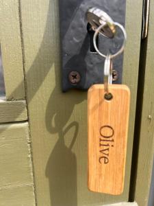 a wooden tag on a door with a keychain at Shepherds Hut in Shropshire with Swimming Pool in Shifnal