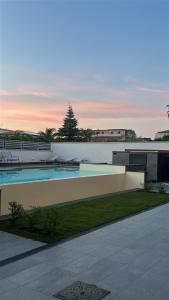 a swimming pool with tables and benches on a building at La BriSa in Capo dʼOrlando