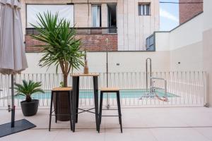 a pair of stools on a balcony with a pool at Hotel Ibis Styles La Rioja Arnedo in Arnedo