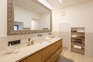 a bathroom with a sink and a mirror at Suite Lazzeri in Cortaccia +21 photos