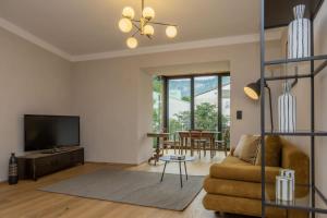 a living room with a couch and a tv at Suite Lazzeri in Cortaccia