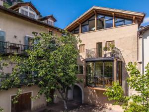 an apartment building with a tree in front of it at Suite Lazzeri in Cortaccia
