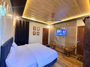 a bedroom with a bed and a tv in it at Lagoon Bites in Jhājra