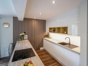 a kitchen with white cabinets and a counter with fruit on it at North Star Apartment - Uk3446 in Greenhaugh +4 photos