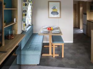 a dining room with a table and a blue bench at Birch 3 - Ukc8216 in Pendine