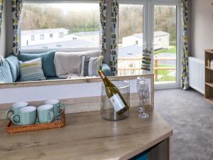 a bottle of wine sitting on a counter in a kitchen at Birch 3 - Ukc8216 in Pendine
