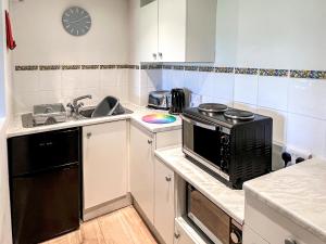 a small kitchen with a sink and a stove at Bramling Apartment - Uk49302 in Woolfardisworthy