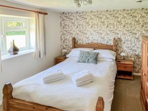 a bedroom with a bed with two towels on it at Bramling Apartment - Uk49302 in Woolfardisworthy