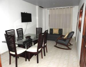 a living room with a table and chairs and a couch at Casa Vacanza Apartamentos in Leticia