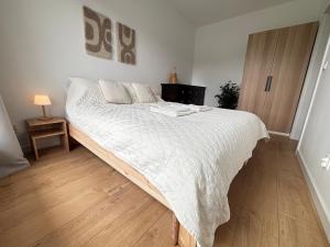 a bedroom with a large bed with a white comforter at Marigold Apartment Łódź in Łódź
