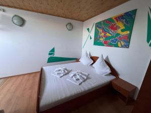 a bedroom with a bed with two towels on it at Casa Silvia in Eforie Nord