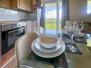 a kitchen with a table with plates and wine glasses at Holly Apartment - Uk49299 in Woolfardisworthy