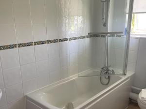 a white bathroom with a tub and a toilet at Holly Apartment - Uk49299 in Woolfardisworthy +18 photos