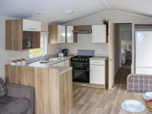 a kitchen with a sink and a stove top oven at Acorn 1 - Ukc8213 in Pendine