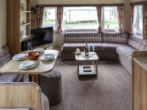 a living room with a couch and a table at Acorn 1 - Ukc8213 in Pendine