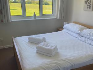 a white bed with two towels on top of it at Chestnut Apartment - Uk49277 in Woolfardisworthy