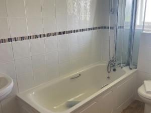 a bathroom with a bath tub and a toilet at Chestnut Apartment - Uk49277 in Woolfardisworthy