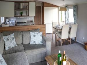 a living room and kitchen with a couch and a table at Birch 1 - Ukc8214 in Pendine
